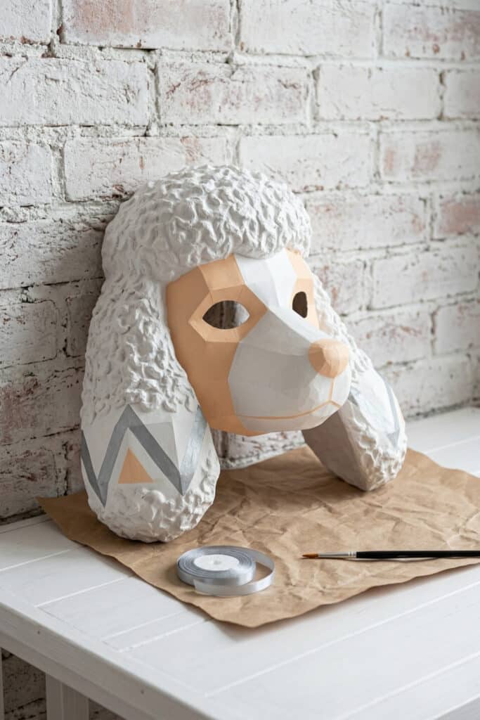 A geometric fancy poodle mask with textured fluffy ears and a sleek modern look using DIY animal mask ideas in soft apricot tones.