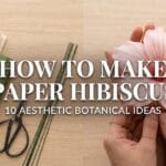 DIY paper hibiscus flowers: A split-screen featured image showing a realistic blush pink crepe paper hibiscus with watercolor details held by artisan hands, next to a flat-lay of fine floral materials.